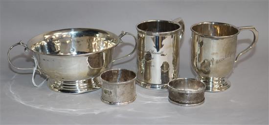 A George V silver two handled porringer, two silver christening mugs and two silver napkin rings.